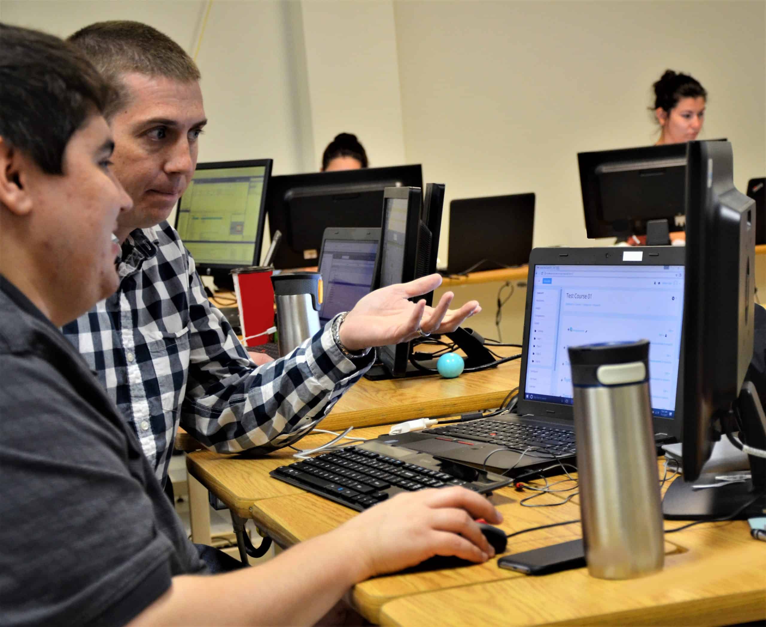 Two Male PQA Employees Working at a Laptop