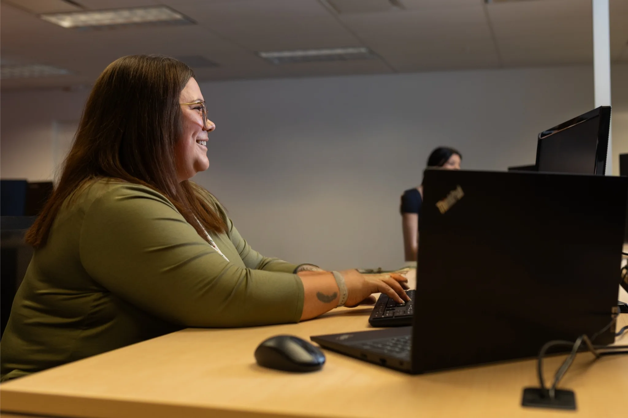 A software tester performs Accessibility Testing while seated in a collaborative workspace.